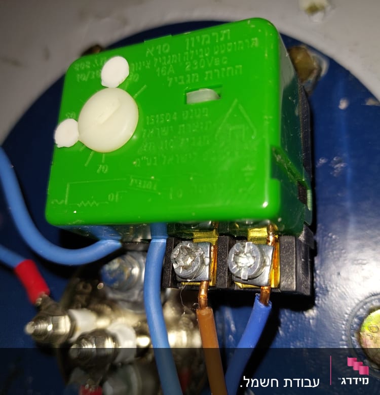 חוטי חשמל מחוברים למפסק ירוק עם כפתור לבן